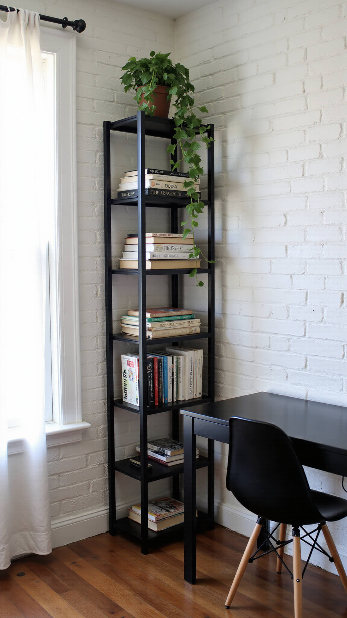 Cozy 8x10 home office nook with tall black metal bookshelf, white brick wall, black desk, Eames-style chair, and morning light filtering through sheer curtains.