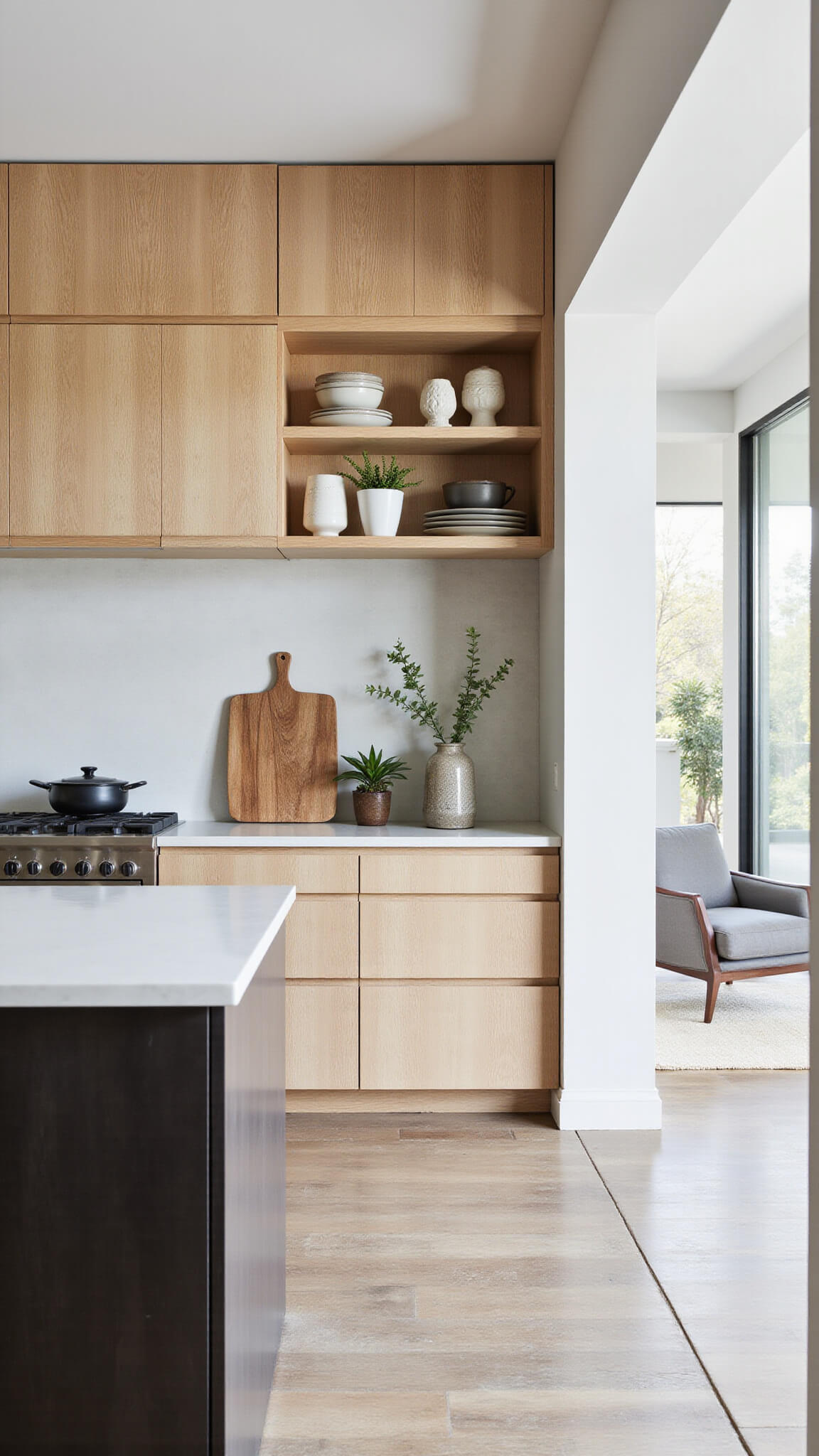 Open-concept kitchen with bleached oak upper cabinets, espresso lower cabinets, floating shelves with pottery, and morning light streaming through tall windows.